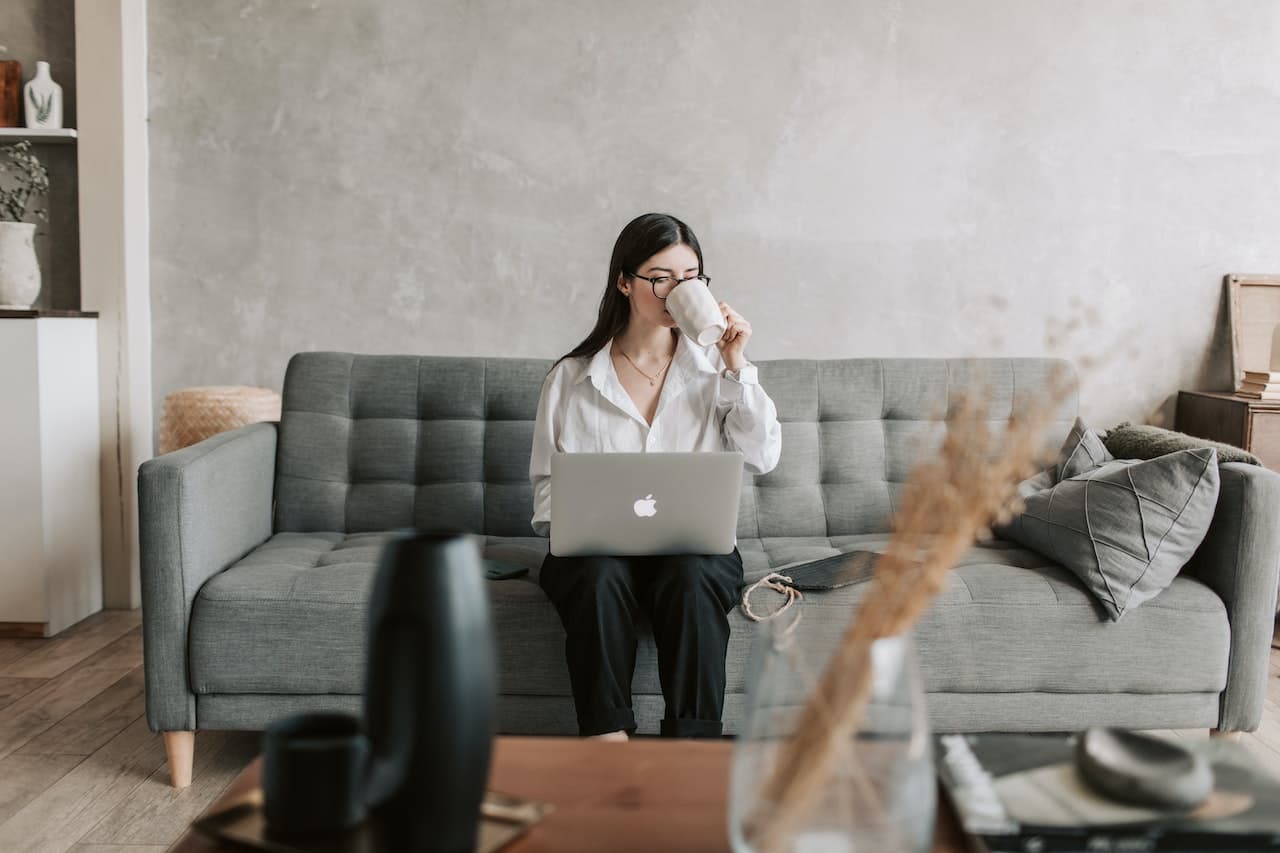 a woman sitting on a couch with a laptop
