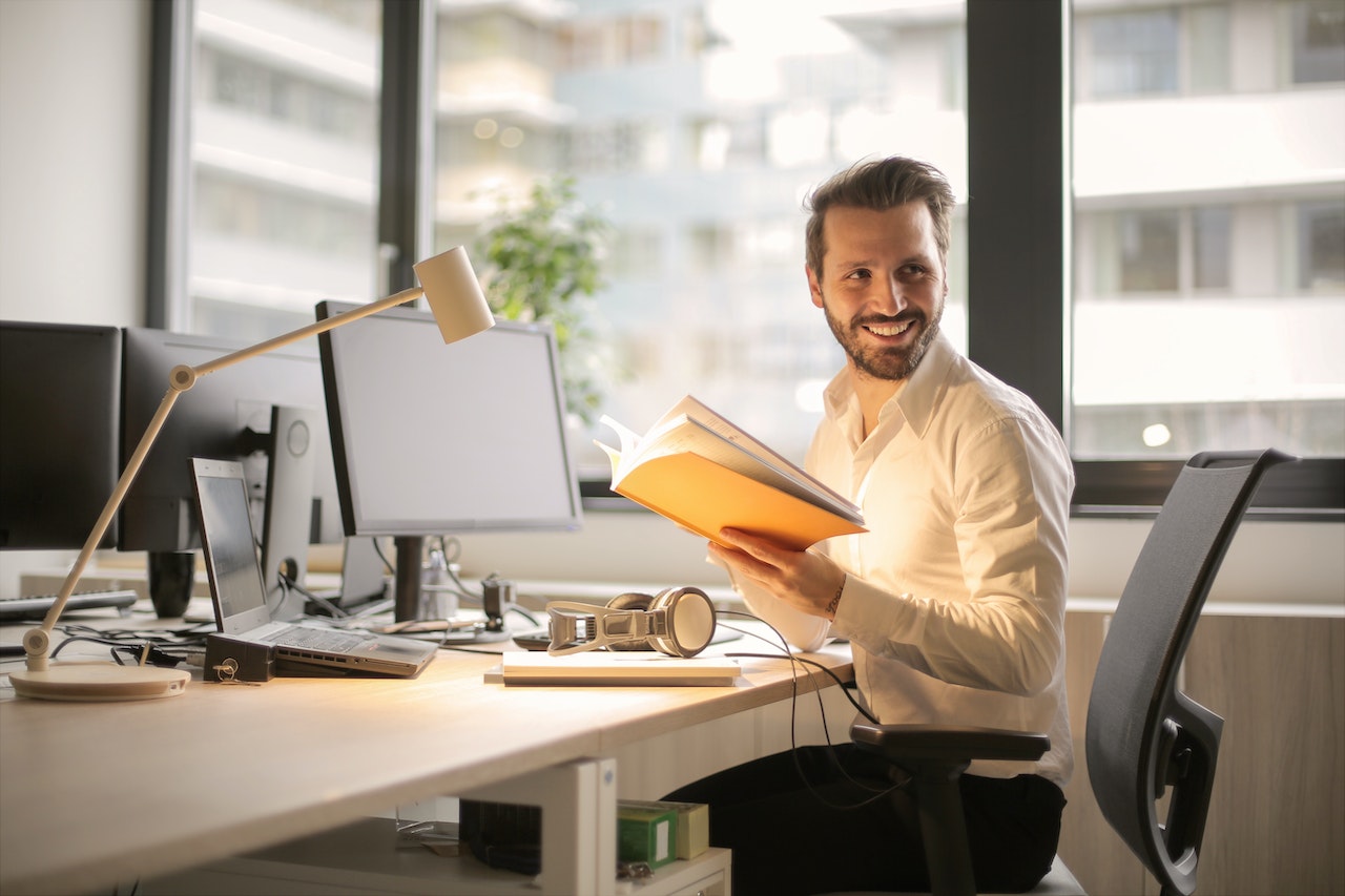 a man sitting by a computer looking to his left